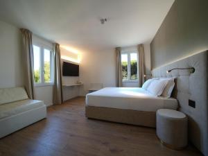a bedroom with a large white bed and a couch at Castiglioncello Suite in Castiglioncello