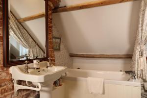 a bathroom with a sink and a bath tub at Carrick's at Castle Farm in Swanton Morley