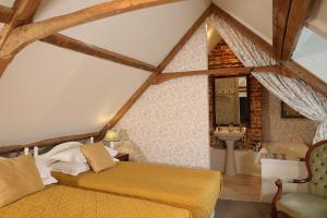 a bedroom with a bed and a sink in a attic at Carrick's at Castle Farm in Swanton Morley