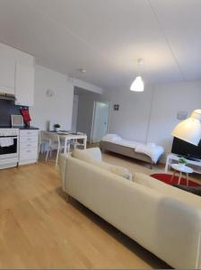 un soggiorno con 2 divani bianchi e una cucina di Kotimaailma- Kalustettu kaksio Rauhallisella alueella Hiekkaharjusta a Vantaa