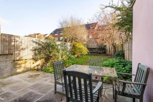 a patio with a table and chairs and a fence at AJ's Stays - FREE WIFI - FREE PARKING - GARDEN - SLEEPS UP TO 7 - 4 BEDS in Bristol