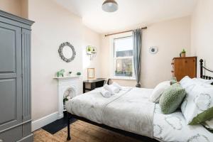 um quarto com uma cama e uma lareira em AJ's Stays - FREE WIFI - FREE PARKING - GARDEN - SLEEPS UP TO 7 - 4 BEDS em Bristol