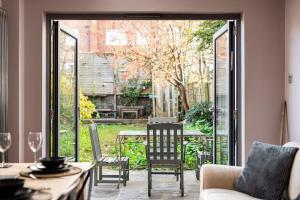 una puerta abierta a un patio con mesa y sillas en AJ's Stays - FREE WIFI - FREE PARKING - GARDEN - SLEEPS UP TO 7 - 4 BEDS, en Bristol