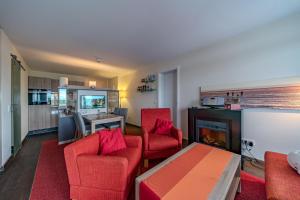 un soggiorno con sedie rosse e camino di Resort Deichgraf Resort Deichgraf 27-08 a Wremen
