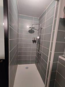 La salle de bains est pourvue d'une douche avec du carrelage gris. dans l'établissement Appartement 2 chambres Terrasse, à Orange
