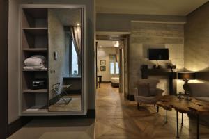 a living room with a table and a mirror at Forvm Experience in Trieste