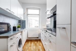 een witte keuken met een wasmachine en droger bij Schöne 3-Zimmer Wohnung in Mannheim/Rheinau in Mannheim