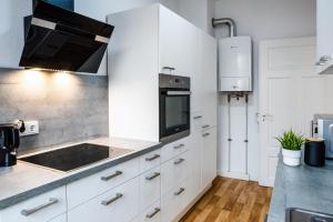 een keuken met witte kasten en een fornuis met oven bij Schöne 3-Zimmer Wohnung in Mannheim/Rheinau in Mannheim