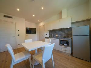 a kitchen with a white table and white chairs at Castiglioncello Suite in Castiglioncello