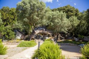 a stone bridge in a park with trees and bushes at Domaine d'Arca - Flaubert 11 - 4 pers - étage 1 in Porto-Vecchio