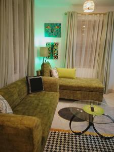 sala de estar con 2 sofás y mesa de cristal en Olive Branch home, en Mombasa