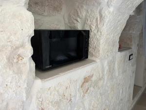 a black microwave sitting on a stone wall at RocknTrullo 2 bedroom by TripOstuni in Ostuni
