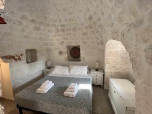 a bedroom with a bed with two towels on it at RocknTrullo 2 bedroom by TripOstuni in Ostuni