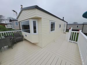 a tiny house on a deck with two benches at Cosy home with stunning views in Holsworthy