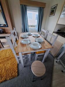 uma mesa de jantar com pratos brancos e cadeiras em Cosy home with stunning views em Holsworthy