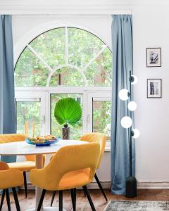 a dining room with a table and chairs and a large window at 1st Class Covent Garden Residences for 1st Class Guests in London