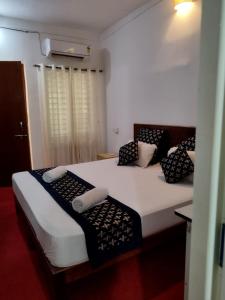 um quarto com 2 camas com almofadas pretas e brancas em Palm Heaven em Canacona