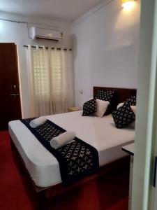 a bedroom with two beds with black and white pillows at Palm Heaven in Canacona