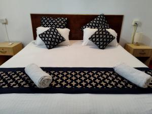 a bed with black and white pillows on it at Palm Heaven in Canacona