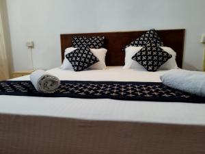 a bed with black and white pillows on it at Palm Heaven in Canacona