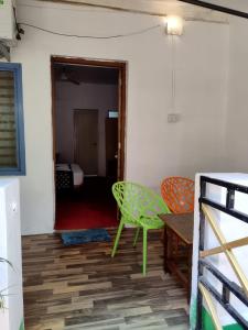 a room with a green chair and a table at Palm Heaven in Canacona