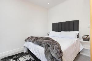 Un dormitorio con una cama con una manta peluda. en Chic Studio Apartment Mountain views Gardens, en Ciudad del Cabo