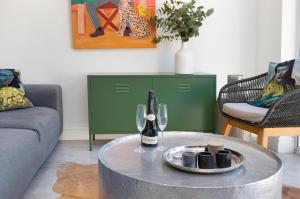 a living room with a table with a bottle of wine at Chic Studio Apartment Mountain views Gardens in Cape Town