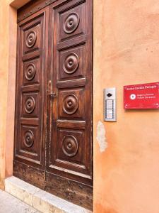 una grande porta di legno sul lato di un edificio di Santa Cecilia Perugia - Rooms&Suite a Perugia