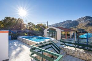 a swimming pool in a yard next to a house at Villa Smajo in Kotlenice