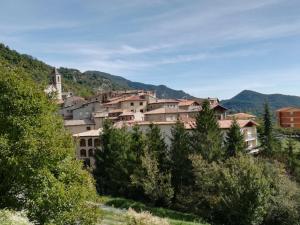 a town on a hill with trees in the foreground at Casa de Colònies Casa Pare Coll in Gombreny