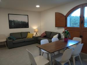 a living room with a couch and a table and chairs at Casa de Colònies Casa Pare Coll in Gombreny