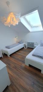 2 camas en una habitación blanca con tragaluz en Five Seasons en Oberstaufen