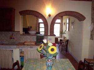 een keuken met een tafel met een vaas met bloemen erop bij Casa Amedeo in Chianni