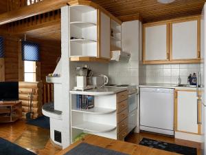 uma cozinha com electrodomésticos brancos e armários de madeira em Kuusivilla 1 em Syöte