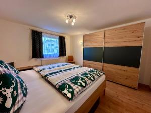ロイタッシュにあるHaus Bergkristallのベッドルーム1室(ベッド1台付)、大きな木製キャビネットが備わります。
