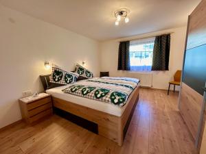 a bedroom with a bed with a wooden floor at Haus Bergkristall in Leutasch