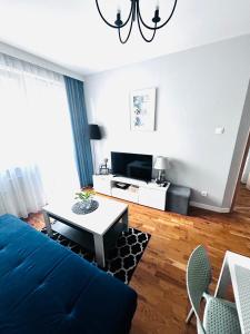een woonkamer met een blauwe bank en een tafel bij Apartament Manhattan in Gorzów Wielkopolski