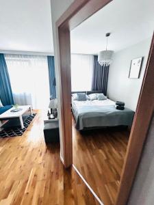 1 dormitorio con cama y espejo en Apartament Manhattan, en Gorzów Wielkopolski