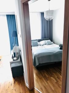 1 dormitorio con cama y espejo en Apartament Manhattan, en Gorzów Wielkopolski