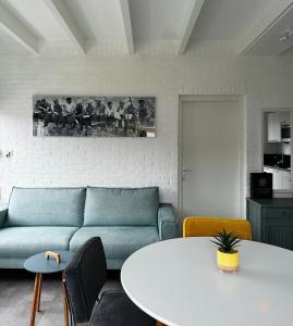 een woonkamer met een bank en een tafel bij -Casa Branca- nabij het meer, strand en keukenhof in Noordwijkerhout