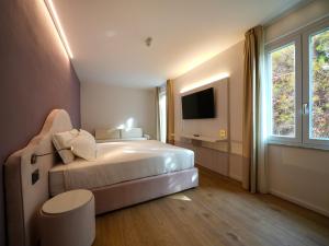 a bedroom with a large bed and a television at Castiglioncello Suite in Castiglioncello