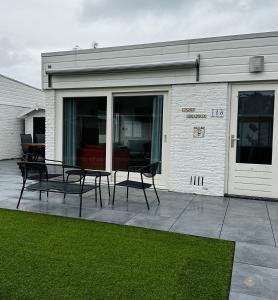 een patio met stoelen en tafels voor een gebouw bij -Casa Branca- nabij het meer, strand en keukenhof in Noordwijkerhout