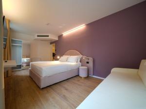 a bedroom with two beds and a purple wall at Castiglioncello Suite in Castiglioncello