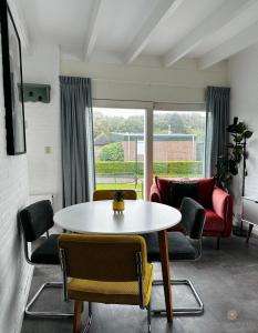 een woonkamer met een tafel en stoelen bij -Casa Branca- nabij het meer, strand en keukenhof in Noordwijkerhout