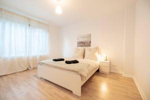 una camera bianca con un letto bianco e una finestra di EXKLUSIVE 2-Zimmer Wohnung Bremen Neustadt 4 Pers. a Brema