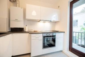 una cucina bianca con piano cottura e finestra di EXKLUSIVE 2-Zimmer Wohnung Bremen Neustadt 4 Pers. a Brema