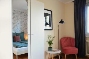 um quarto com uma cama e uma cadeira vermelha em Ferienhaus zum Glück, mit Pool und Kamin em Gerswalde