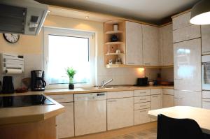 a kitchen with white cabinets and a large window at Ferienhaus zum Glück, mit Pool und Kamin in Gerswalde
