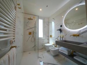 a bathroom with a sink and a toilet and a mirror at Castiglioncello Suite in Castiglioncello