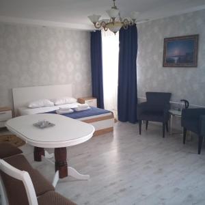 Habitación de hotel con cama, mesa y sillas en Гостиница ,,Меркурий и К,, en Astaná